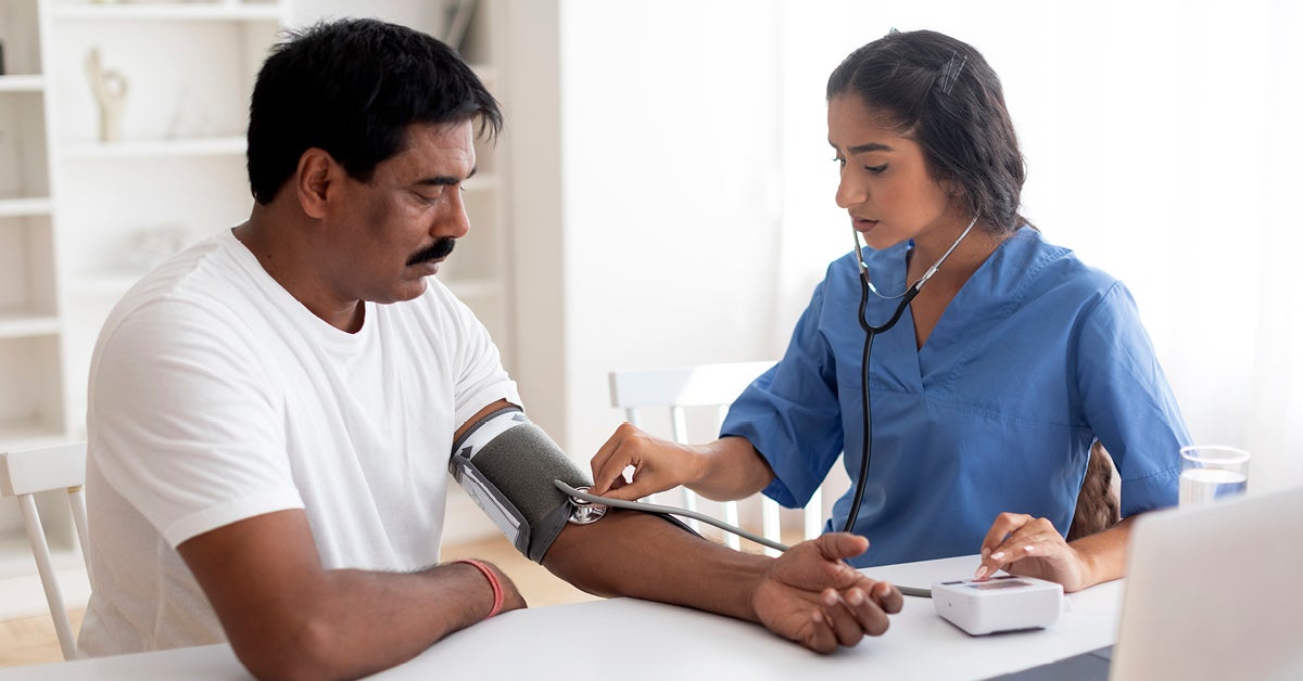 doctor checking man's blood pressure