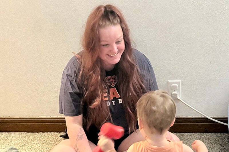 Allison Dussliere playing with her child on the floor