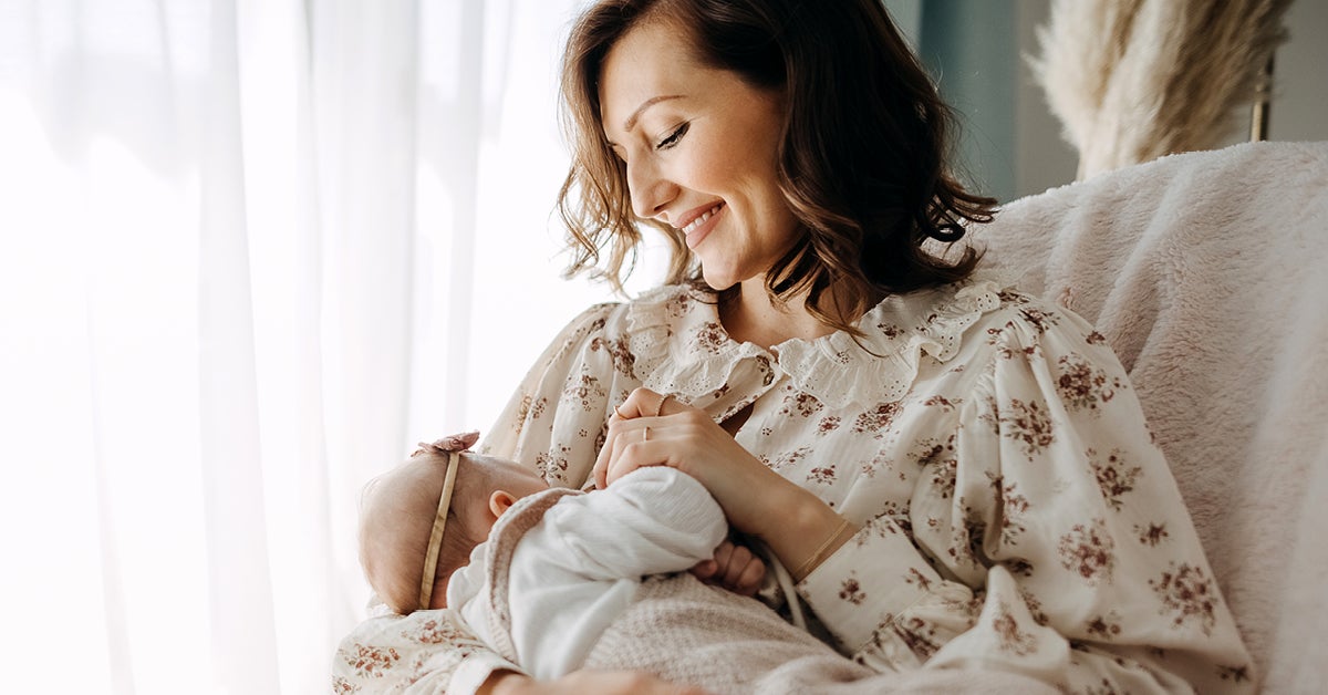 women feeding her baby by breast in a chair