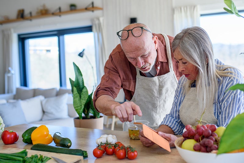 A man and a woman in aprons looking at a phone