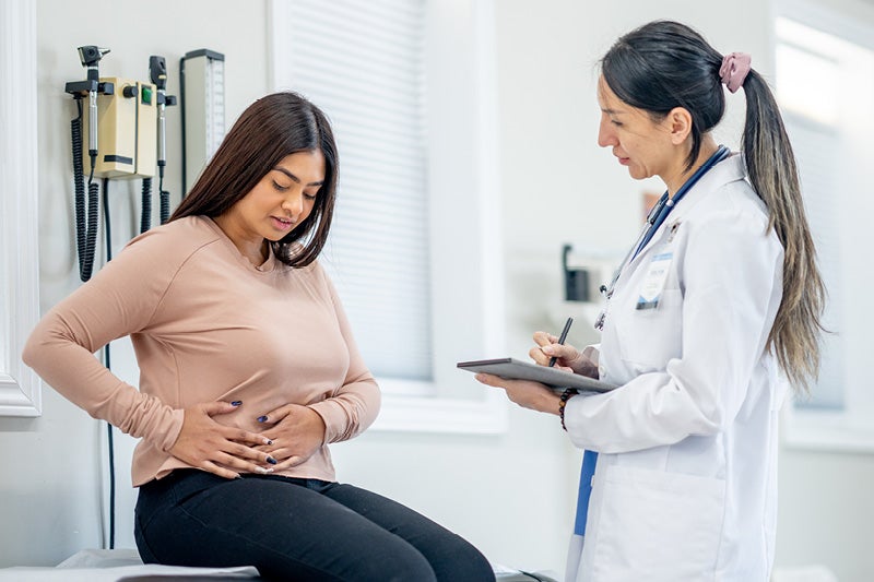 Doctor examining a woman's side