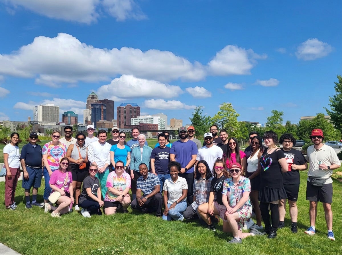 Healthcare team members gather outside on a sunny day.