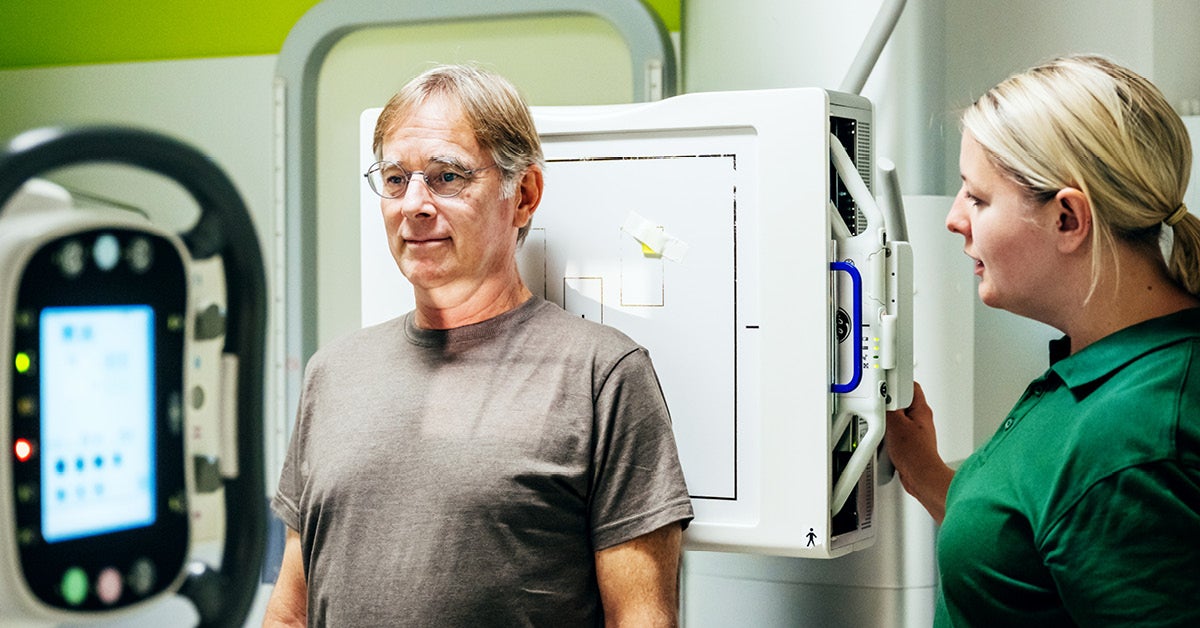 A care team member helps a patient during a scan.