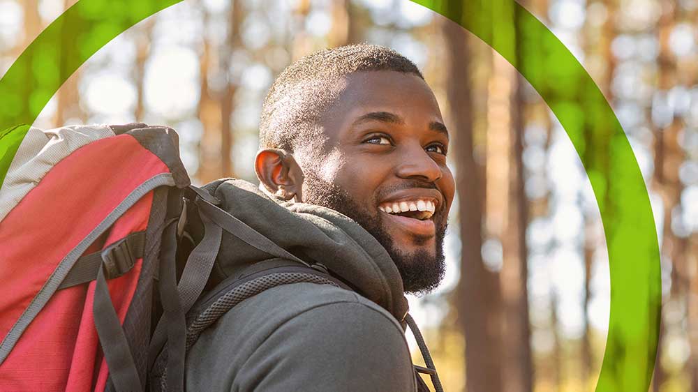 young man smiling while hiking
