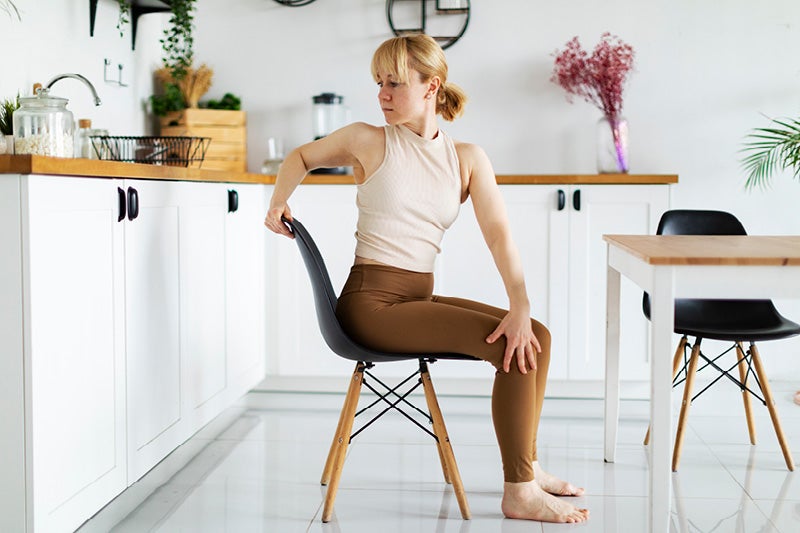 Women sitting on a chair stretching her back