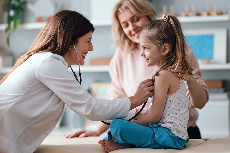 Doctor listening to a girl's heart