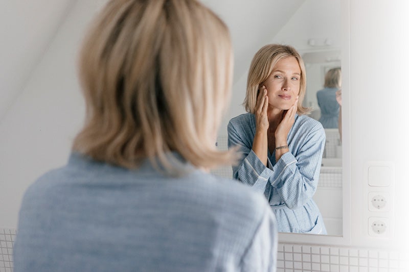 Women examining her face in the mirror